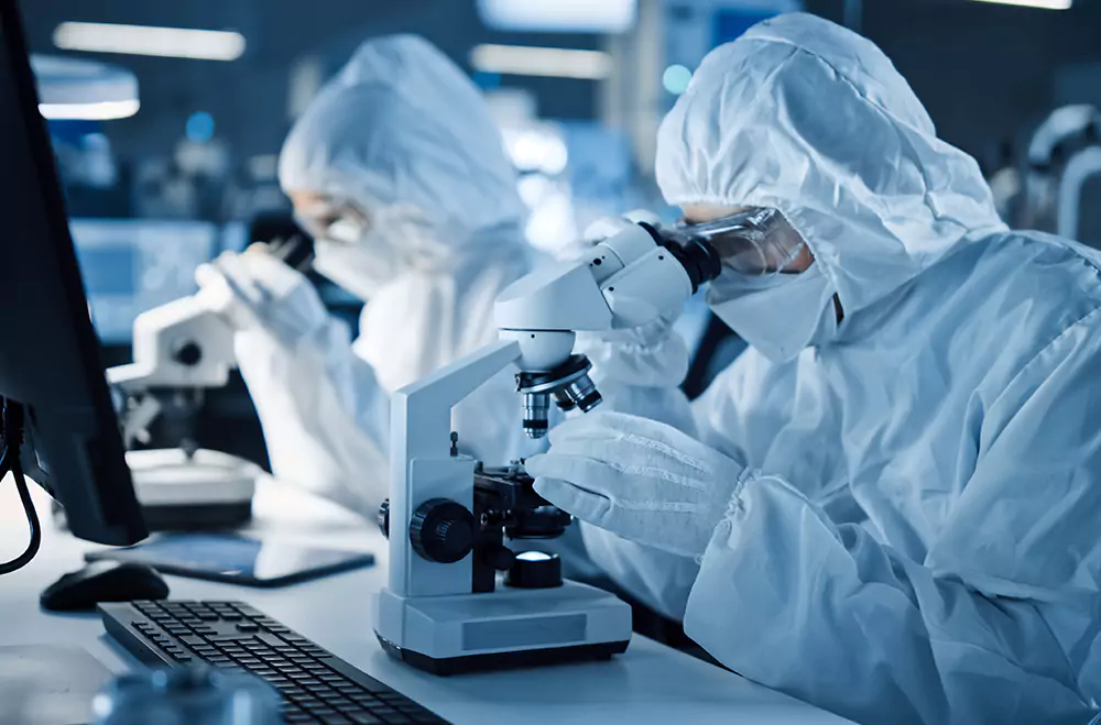 Two people looking in microscope